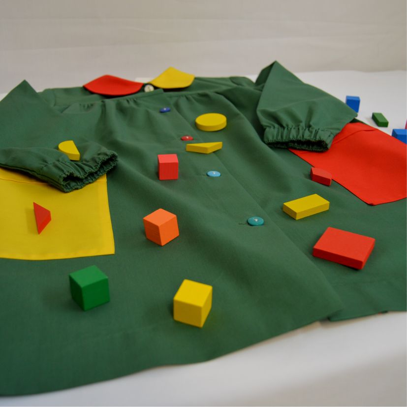 babi escolar verde con bolsillos amarillo y rojo