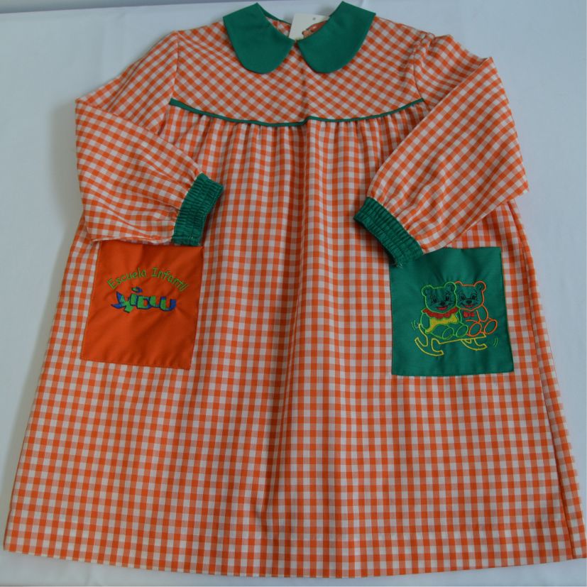 babi escolar naranja con bolsillos rojo y verde