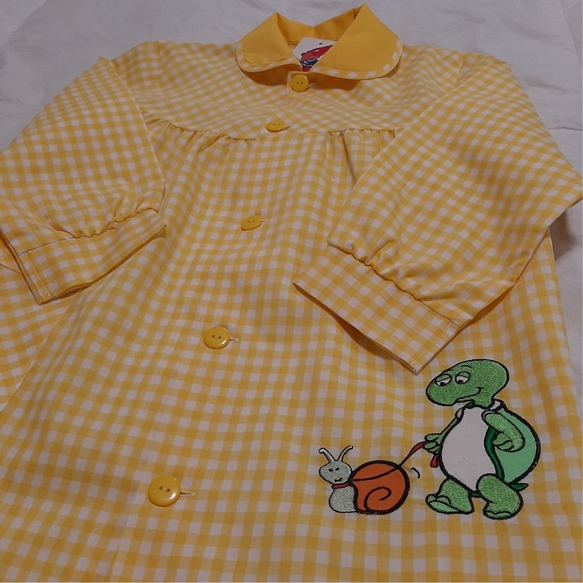 babi escolar amarillo y blanco con un estampado